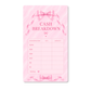 Dreamy Ribbon Cash Breakdown Card displayed inside a pink A6 cash stuffing binder with gold rings on a white marble desk, featuring a feminine pink ribbon design for tracking cash denominations.