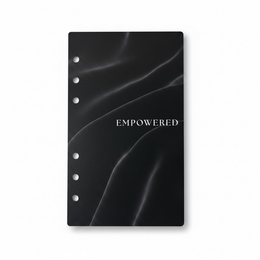 Black planner cover with 'EMPOWERED' text on a white background