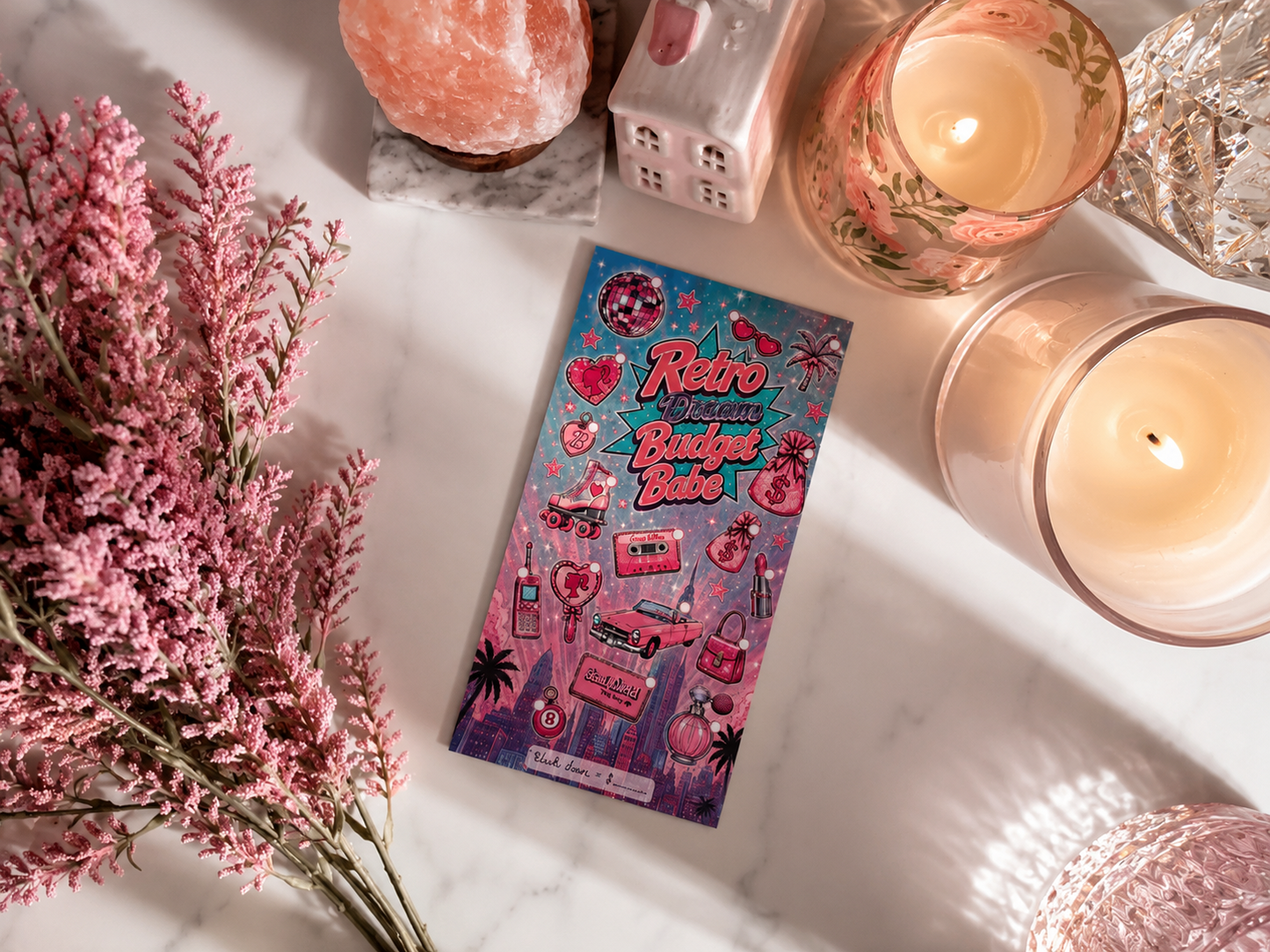 Retro Dream Budget Babe A6 savings challenge dashboard inside a pink cash stuffing binder featuring retro-inspired pink and teal graphics, including a vintage car, roller skates, perfume, lipstick, money bags, and disco ball, styled with a Himalayan salt lamp, floral candle, and cozy feminine desk decor.